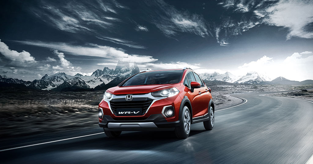 Red Colour Honda WRV car on road with Mountains in Background